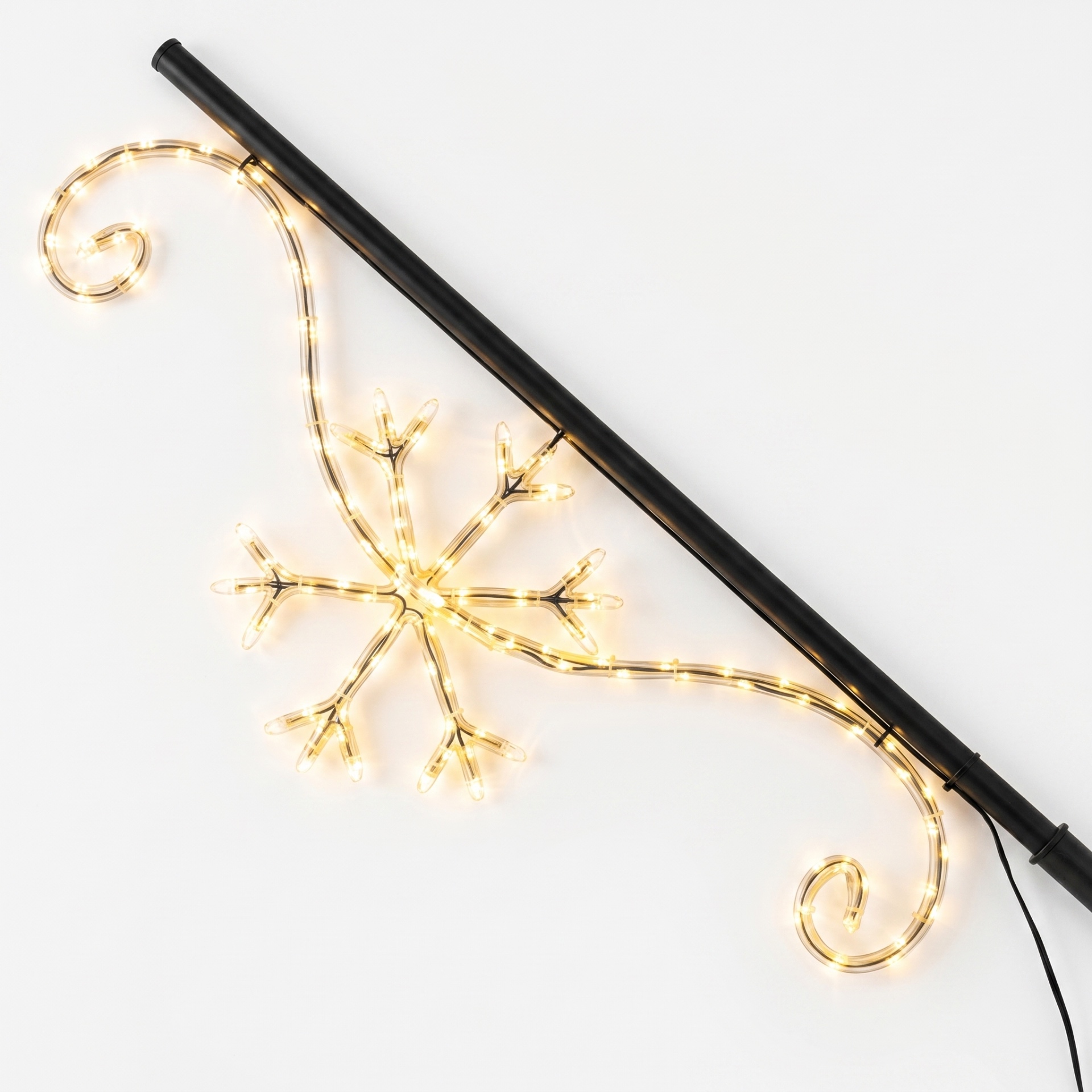 Twinkle Pole met sneeuwvlok-design op een bakstenen gevel